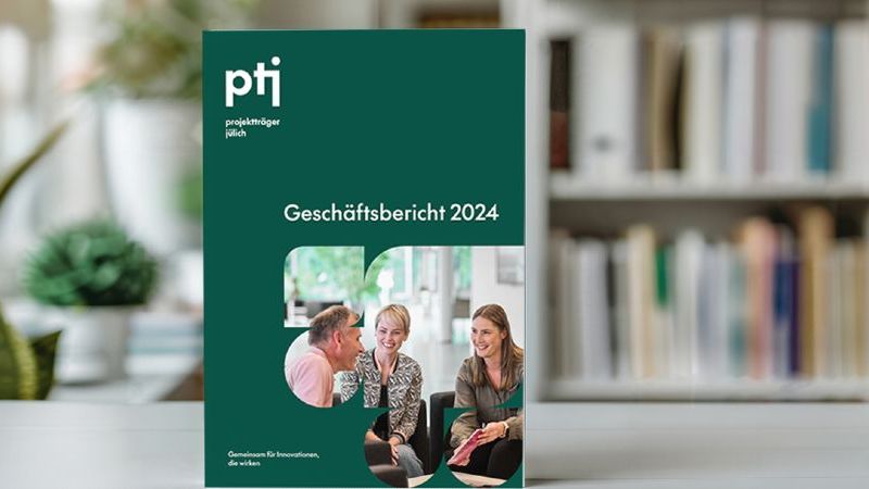 Das Bild zeigt eine gedruckte Ausgabe des PtJ Geschäftsberichts 2024. 