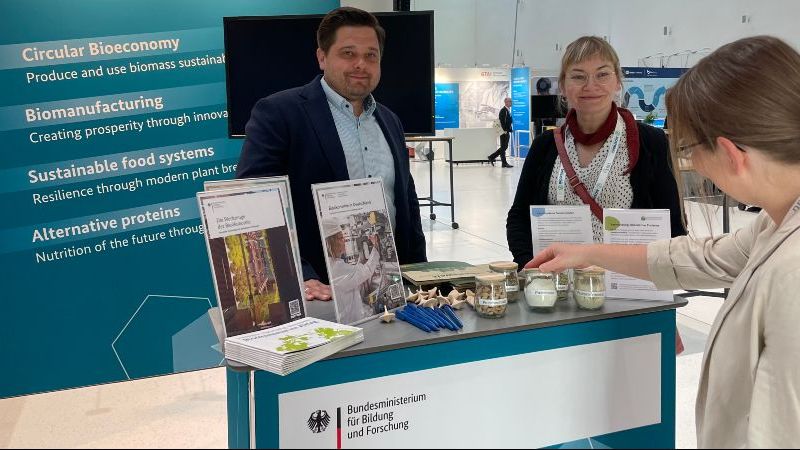 © Projektträger Jülich Das Bild zeigt drei Personen vor einem Messestand auf den BiotechDays 2025.