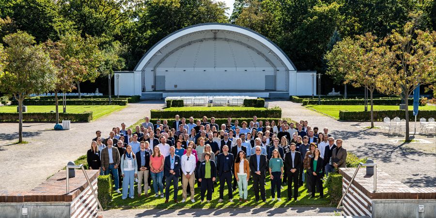 Das Bild zeigt Menschen vor einer Outdoor-Bühne.