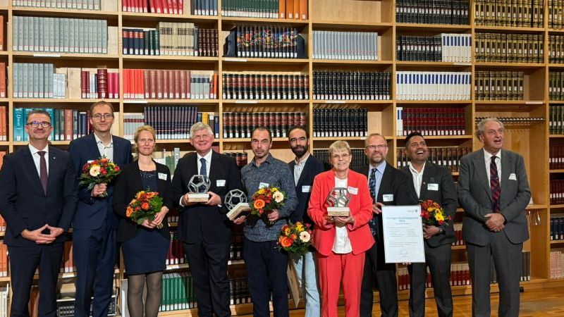 © HSN Das Bild zeigt Menschen vor einer großen Bücherwand.