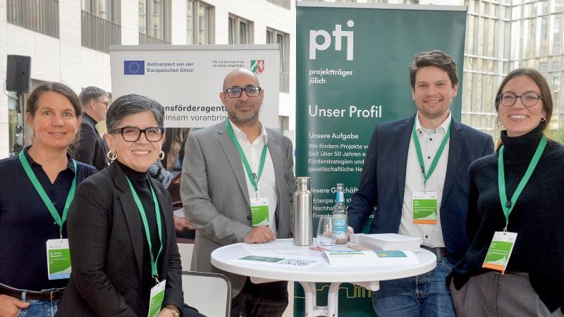 Das Bild zeigt fünf Menschen an einem Messestand.
