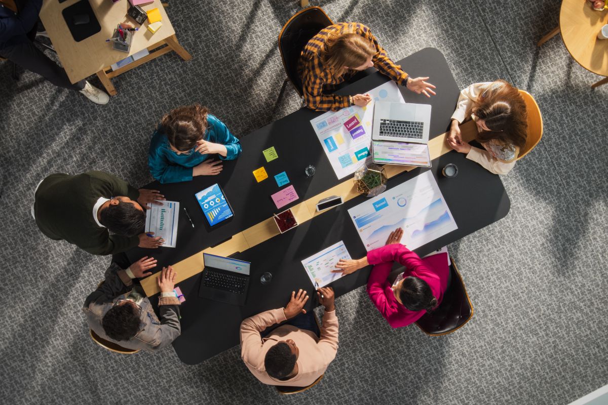 Einige junge Leute sitzen an einem Tisch und tauschen sich aus.