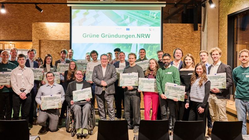 Das Bild zeigt die Gewinner:innen der Förderung Grüne.Gründungen.NRW mit ihren Förderurkunden mit dem NRW-Minister Oliver Krischer.
