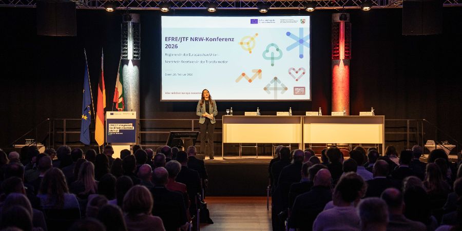 Das Bild zeigt eine Frau auf der Redner-Bühne der EFRE/JTF-Konferenz 2026