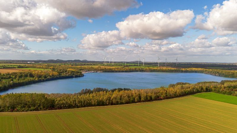 © mitifoto – stock.adobe.com Das Bild zeigt eine Landschaftsaufnahme des Rheinischen Reviers, im Hintergrund Windräder.