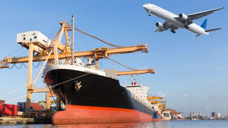 Das Bild zeigt einen Hafen, ein Frachtschiff und ein Flugzeug
