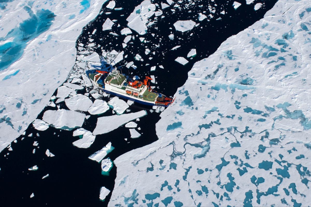Ein Forschungsschriff fährt auf einem zugefrorenem Meer.