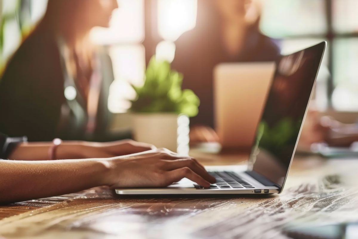 Mehrere Frauen sitzen nebeneinander. Alle haben ein Laptop vor sich stehen.