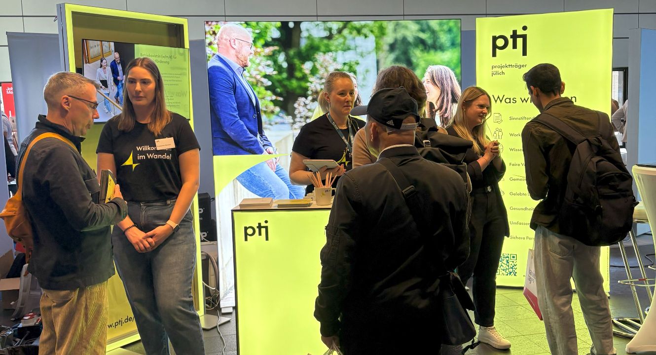 Auf dem Bild sind vier PtJ-Mitarbeiterinnen vor dem PtJ-Karrierestand zu sehen.