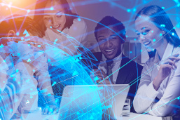 Das Bild zeigt ein Team zufriedener Mitarbeiter, die auf einen Laptop schauen. Eine Doppelbelichtung zeigt ein Bild der globalen digitalen Welt als Hologramm. 