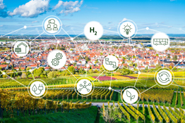 Im Vordergrund ein Weinanbaugebiet mit Ortschaft im Hintergrund und einem Netz aus Wasserstoffsymbolen grafisch gestaltet