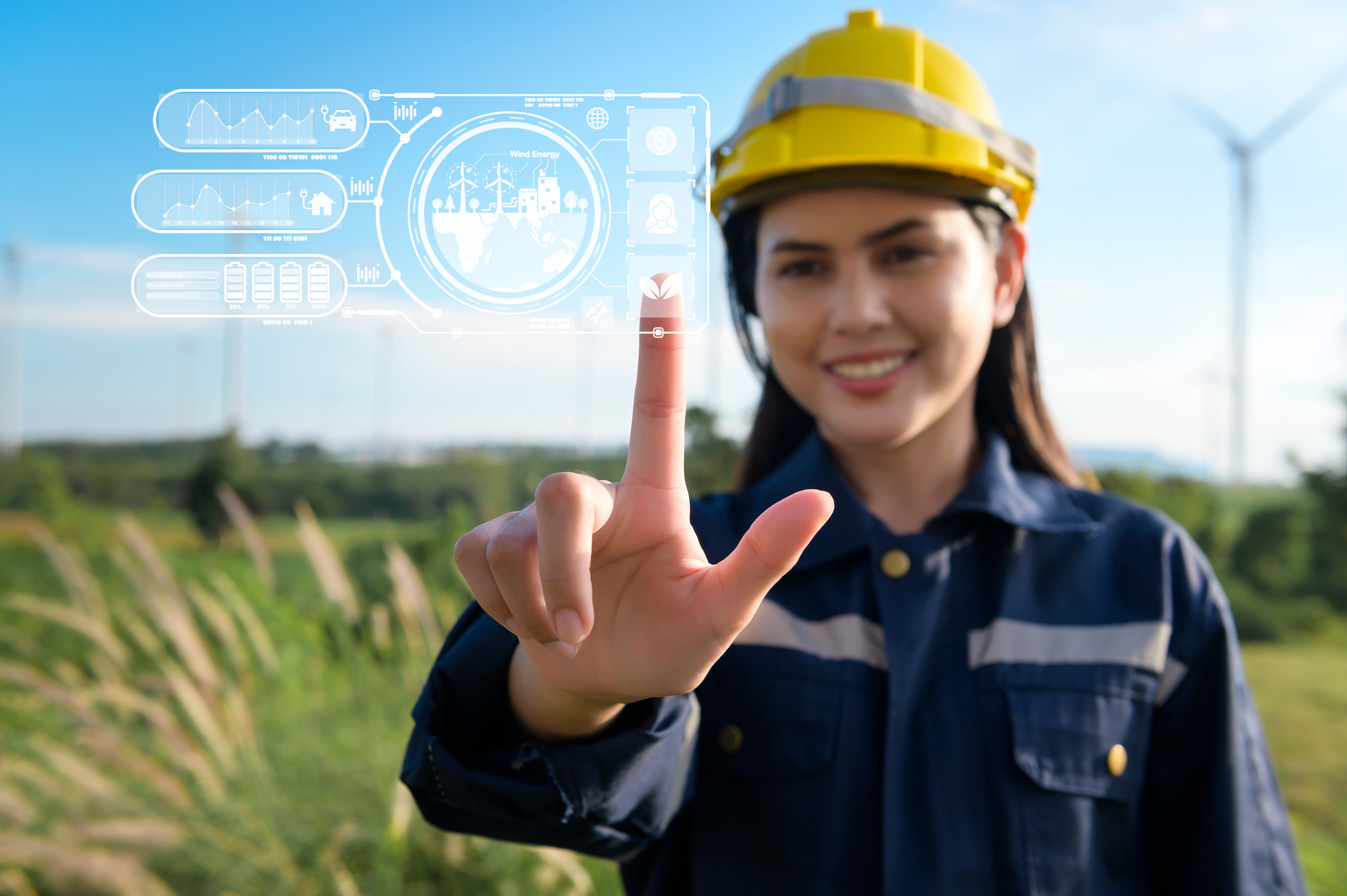 Frau mit Schutzhelm steht auf Feld mit Windrädern. Sie berurüht eine digiale Grafik im Vordergrund.