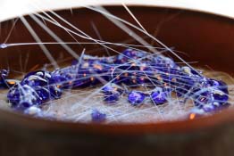 The image shows blue glass drops on quartz sand in molten glass.